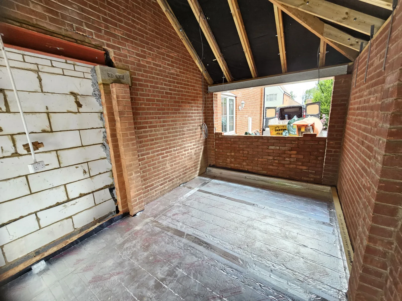 Brick garage interior under renovation showing floor and structural work in progress