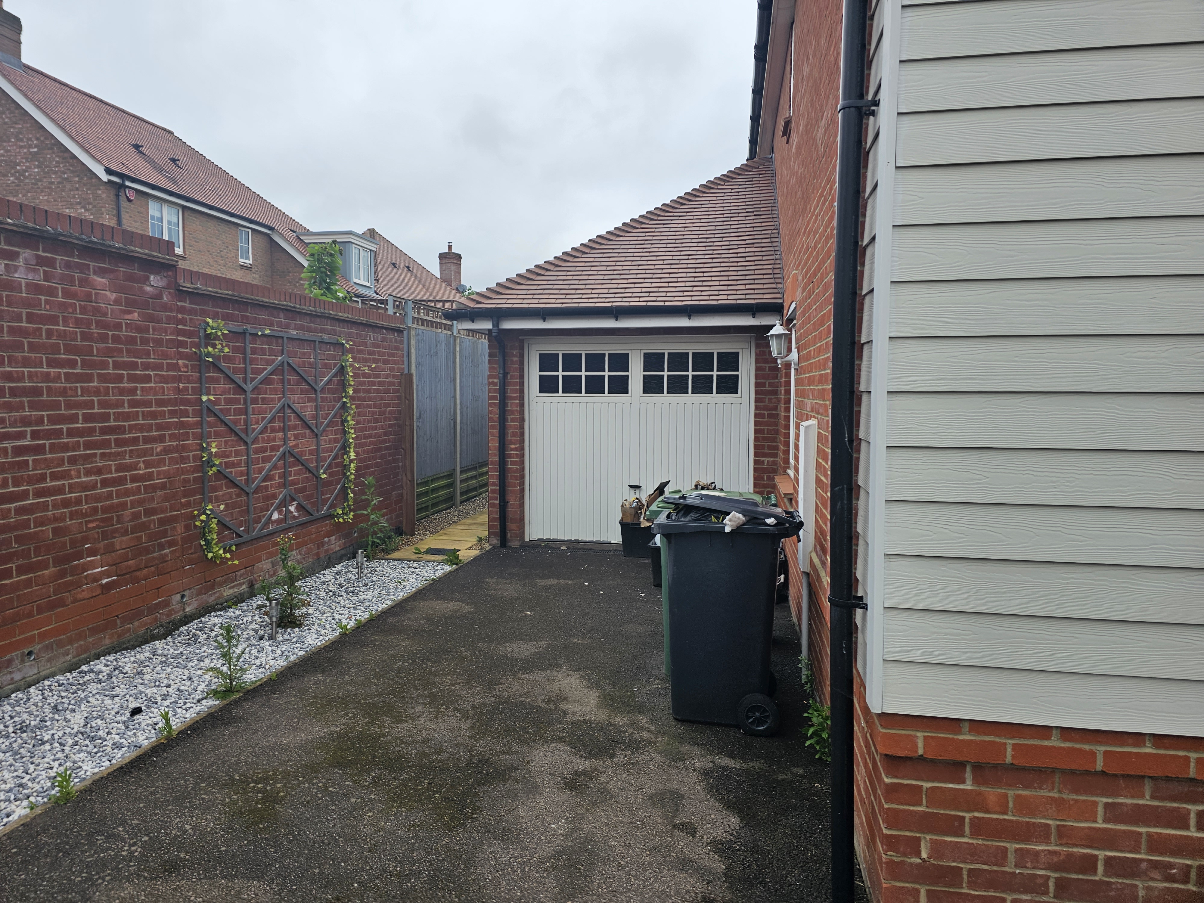 Original garage exterior with up-and-over door and brick walls — Huxley Close, before conversion