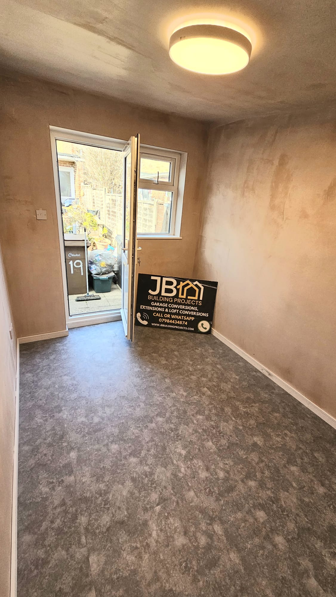 Original handover photograph of the converted room with grey flooring and new rear glazing — Chelmsford