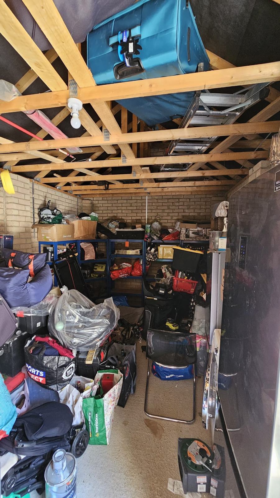 Original Dunmow garage filled with household storage beneath exposed roof timbers