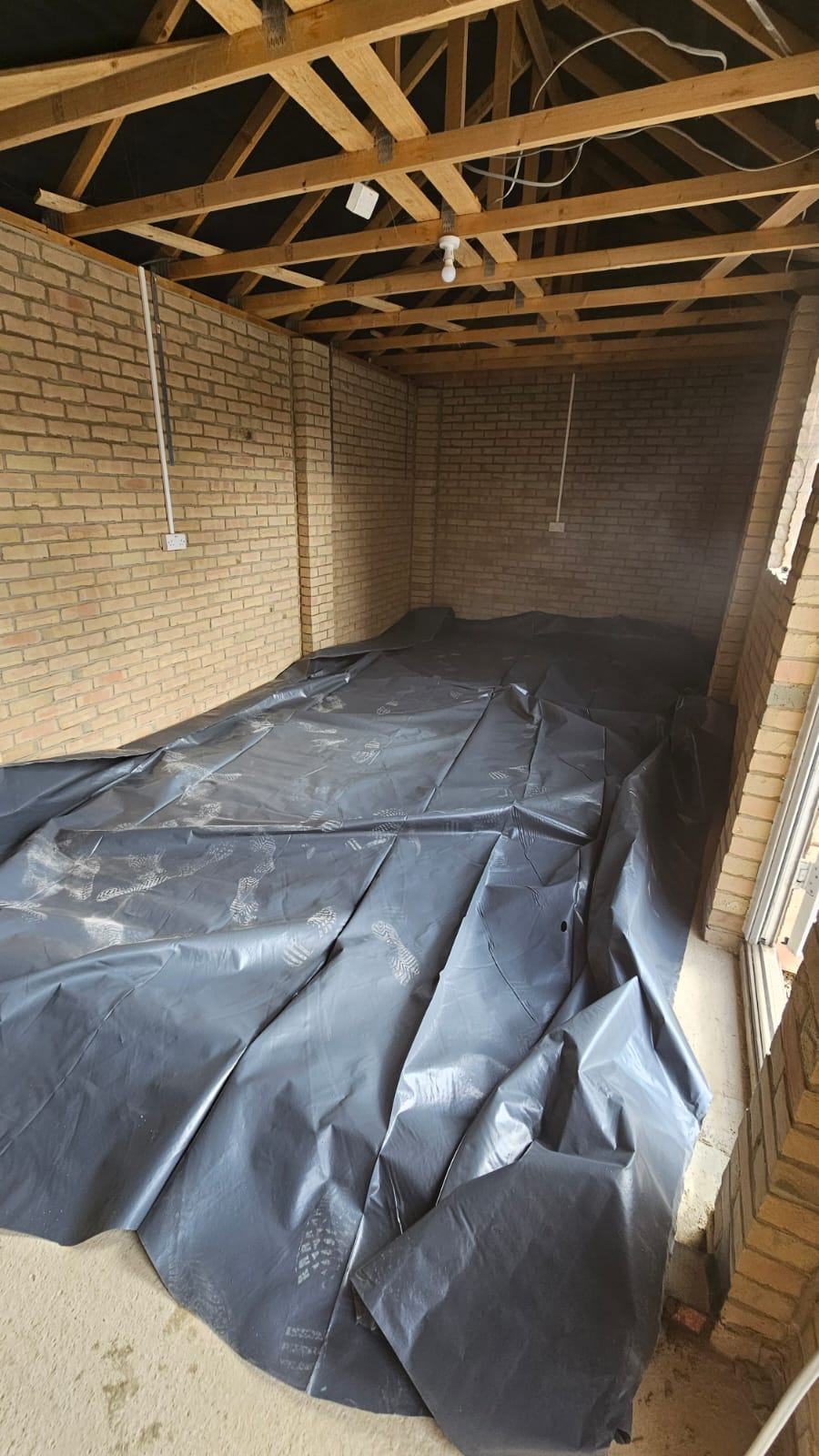 Protective floor membrane laid over the concrete slab inside the Dunmow garage office area