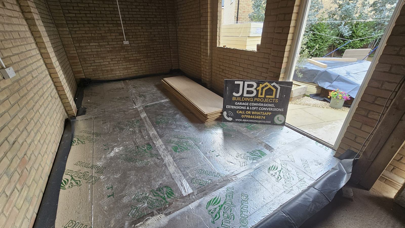 Wide interior view showing foil-faced floor insulation with taped joints before the floor deck was installed