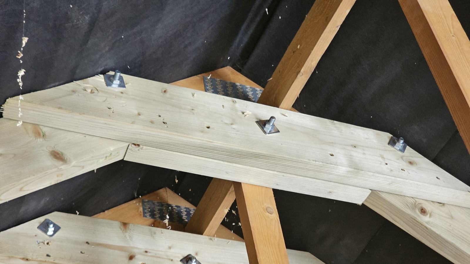 Close view of new bolted timber members installed within the Dunmow garage roof structure