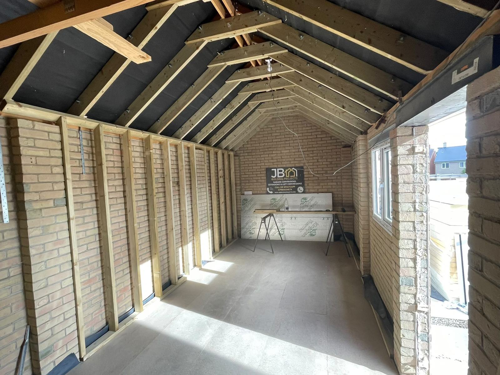 Timber wall lining, floor deck and new window in the Dunmow garage office before insulation and plastering