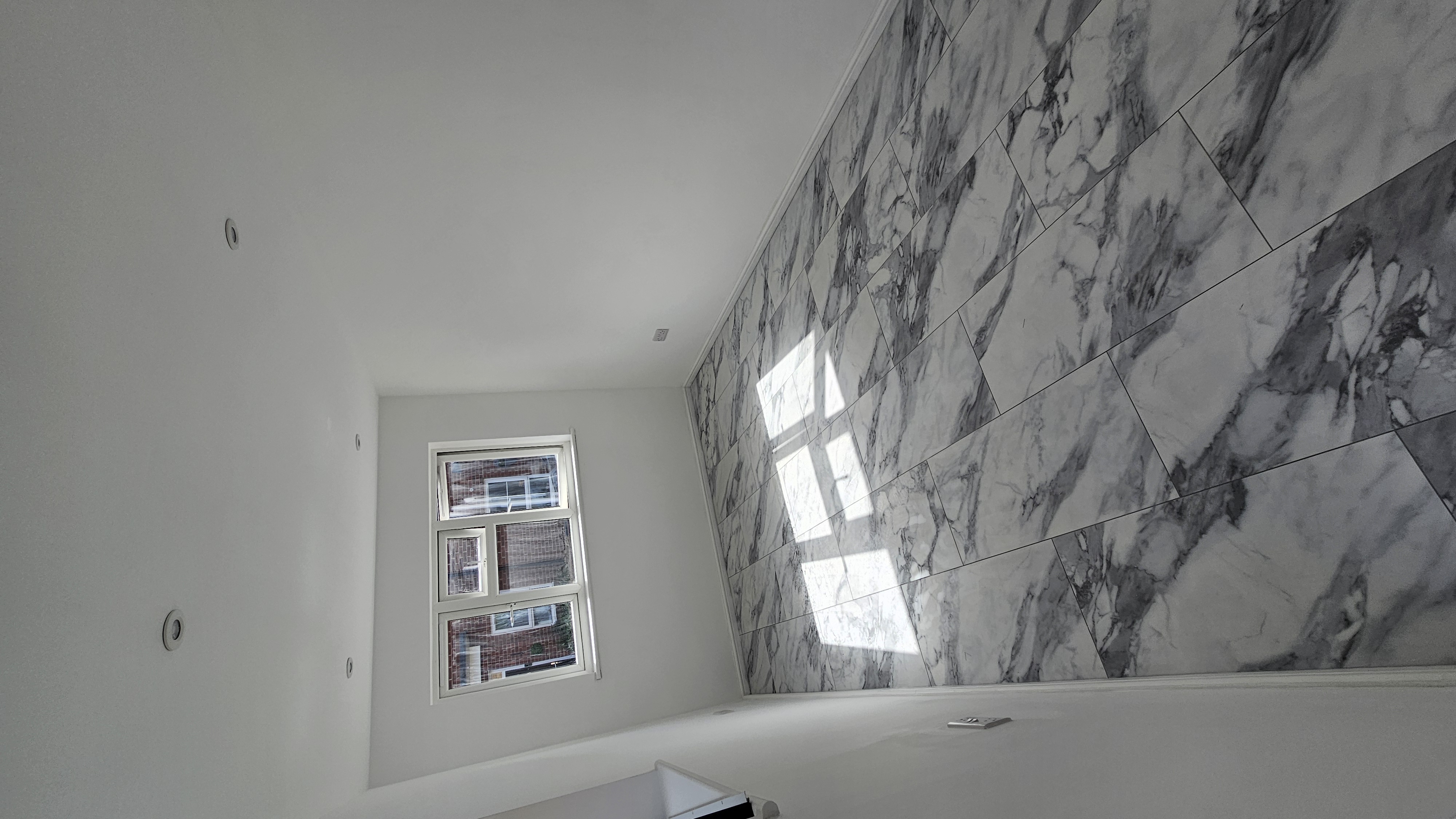 Completed detached garage office conversion in Hatfield with marble-effect flooring, white walls and recessed lighting