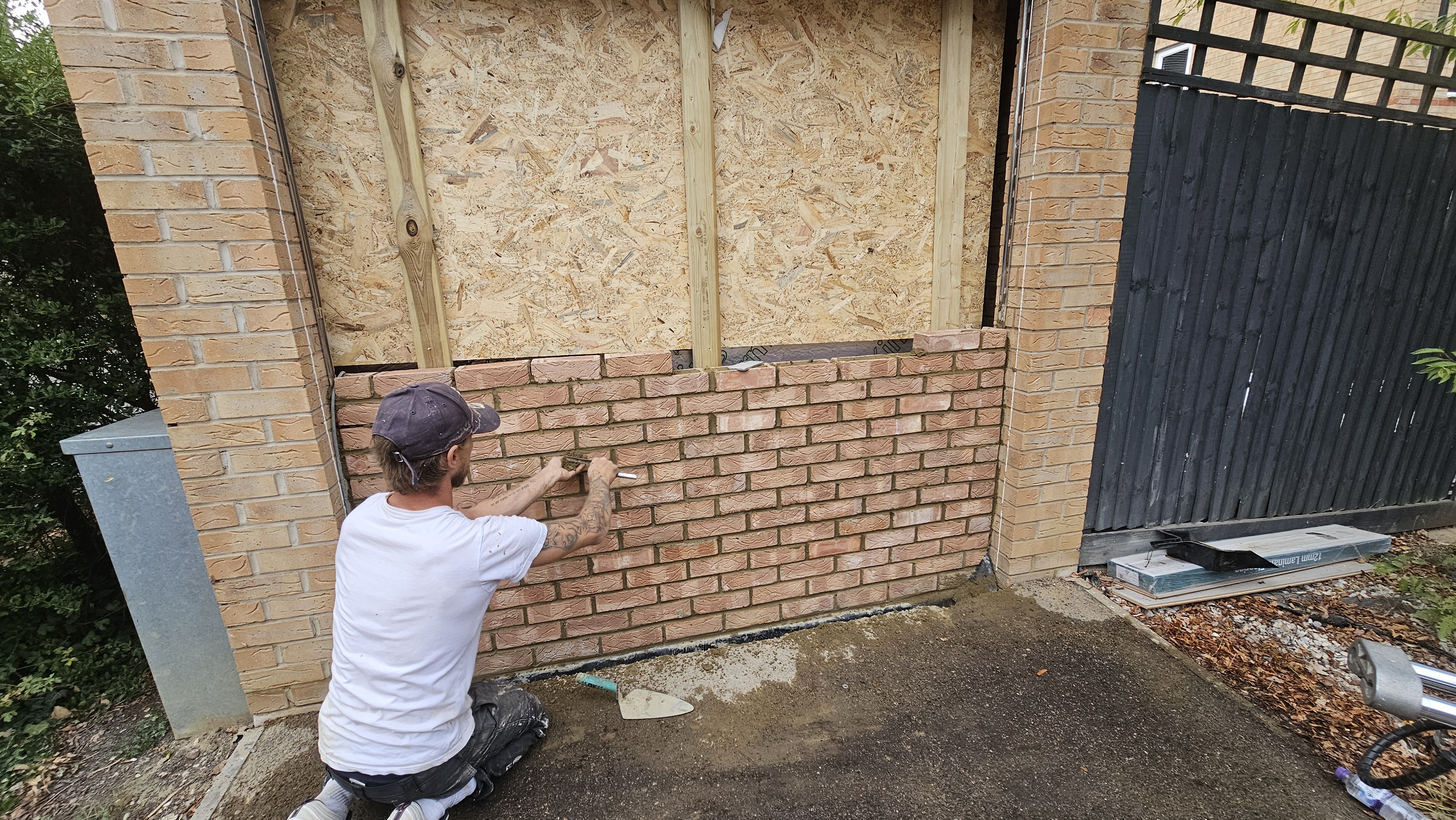Matching brickwork being laid across the former garage opening in Hatfield