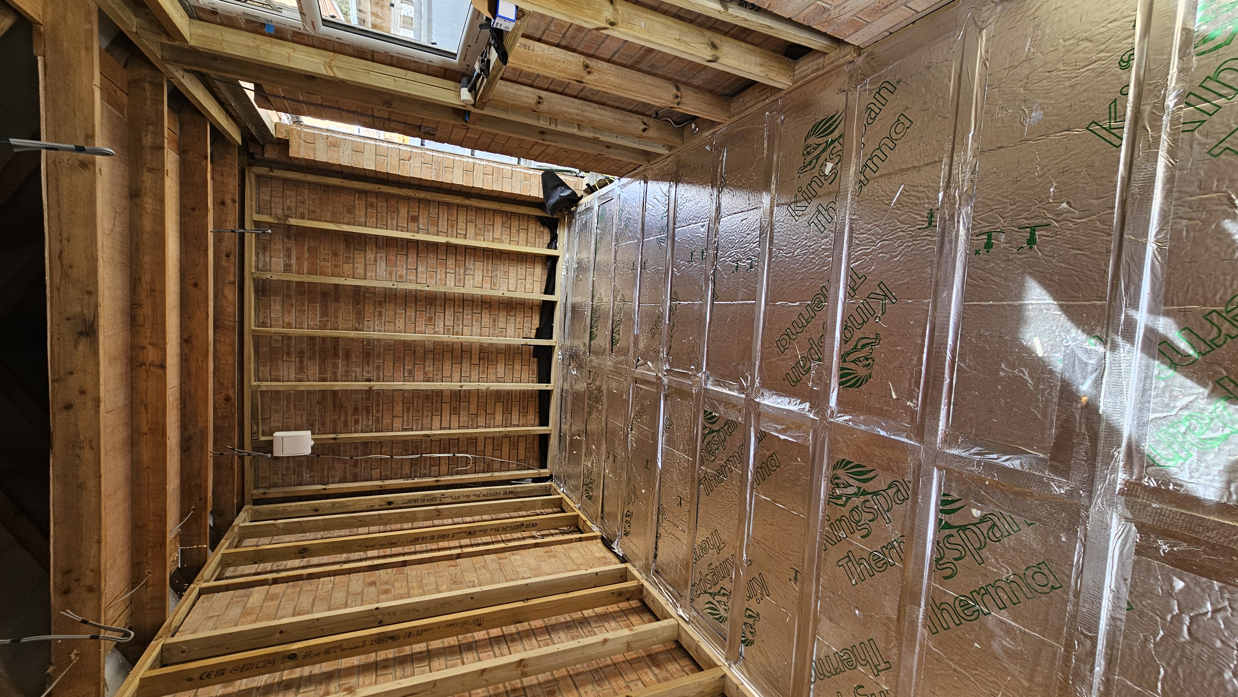 Independent timber wall linings installed inside the brick garage shell