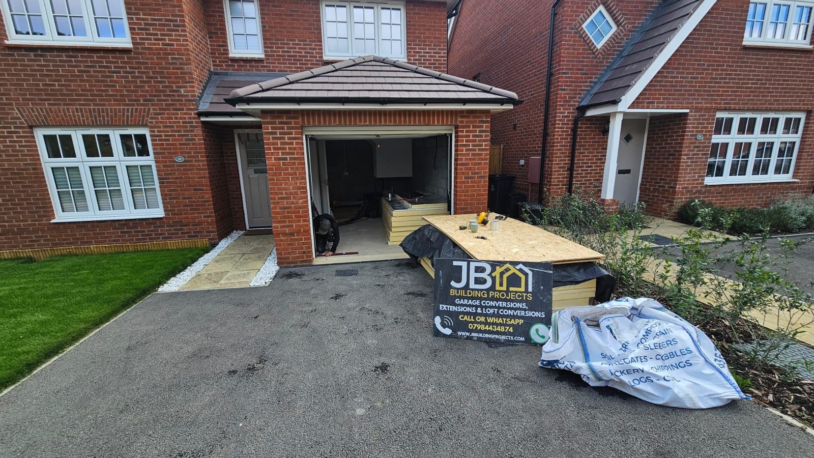 The existing garage frontage in Waltham Cross during early preparation, with the vehicle opening still visible and materials on the driveway